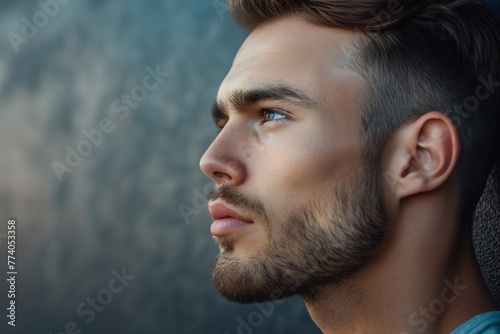 Close-up photo capturing the details of a man's modern undercut hairstyle and his thoughtful expression photo