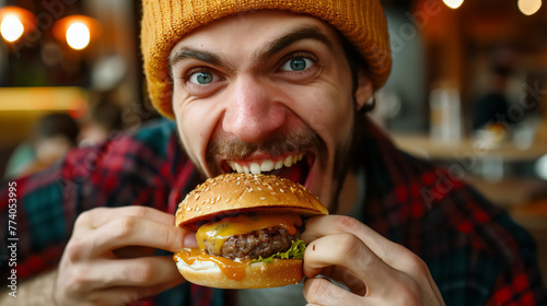 A man enjoying a hamburger fast food meal in the fast food restaurant.