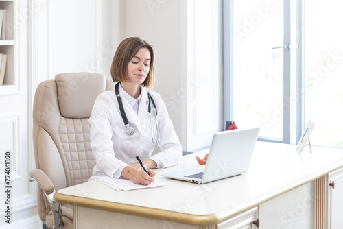 Portrait of young female doctor cardiologist working in office of modern clinic 