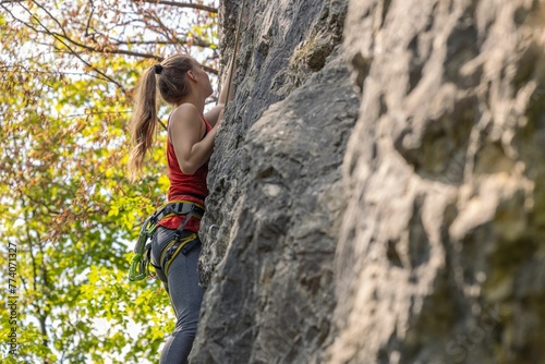 Girl climbing a cliff. Rock climbing, sport concept.