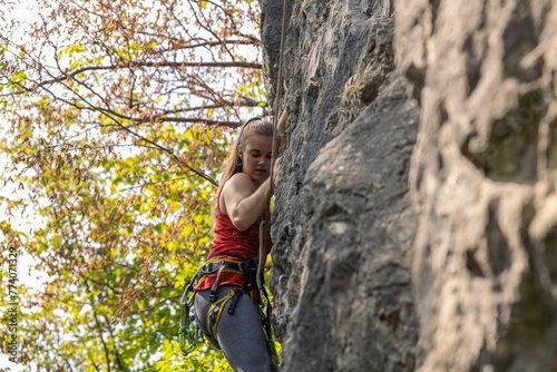 Girl climbing a cliff. Rock climbing, sport concept.