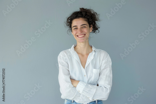 Radiant Young Woman Smiling Confidently with Arms Crossed