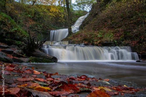 Fototapeta Naklejka Na Ścianę i Meble -  Long exposure of the Scaleber Force waterfall flowing down a beautiful hill in United Kingdom