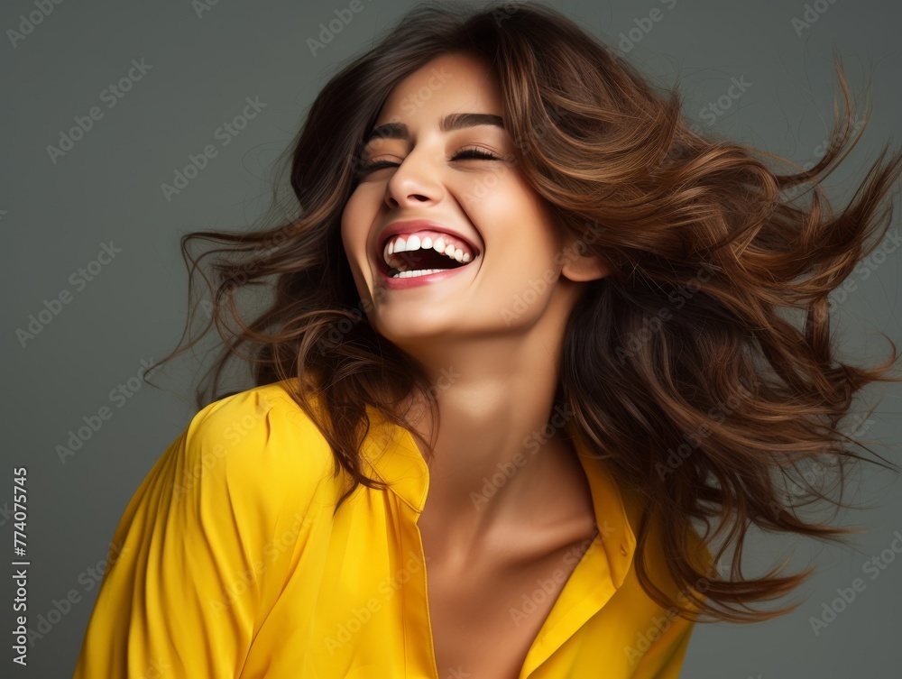 A woman with long hair is smiling and laughing while wearing bright clothing A woman with long hair is smiling and laughing while wearing bright clothing