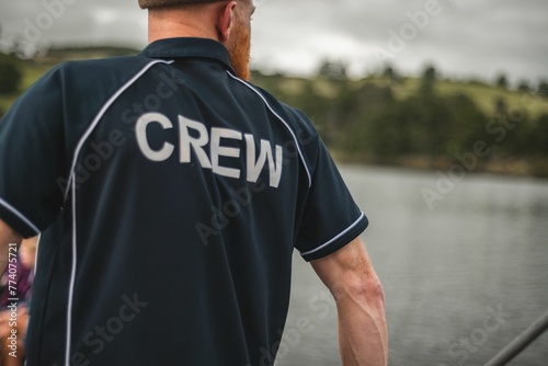 Young man wearing a polo shirt with the word Crew