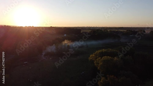 Aerial view of the sunrise and a small smoke trail coming up from the ground in Titchfield, UK photo