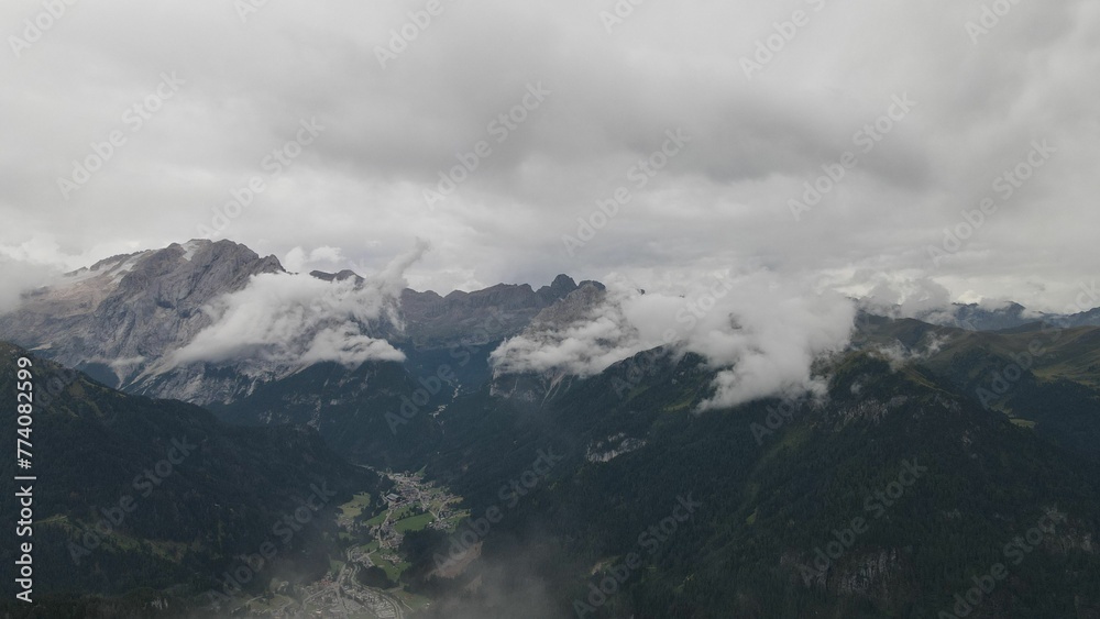 Mountain peaks of Italian Dolomites hiding behind the fog