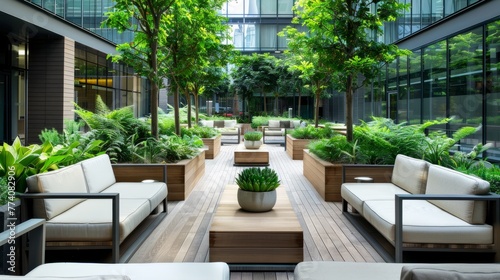 A commercial outdoor meeting space featuring couches, tables, and potted plants for employees to work, have meetings, or relax
