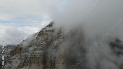 Aerial of the mountain peaks of Italian Dolomites hiding behind the fog