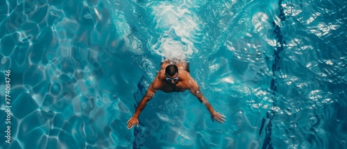 Using Front Crawl, Freestyle Technique, a male swimmer flies at top speed in a swimming pool. Aerial top view shot of a male swimmer flies at top speed in a swimming pool.