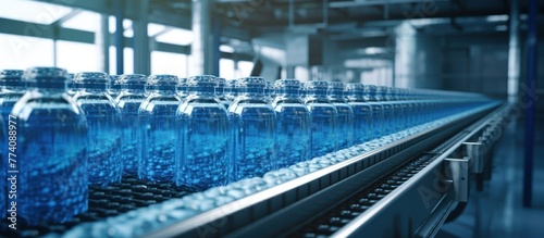 blue PE water storage tank or PEA bottle on production line of conveyor belt at beverage filling machine