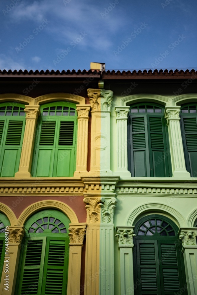 Fototapeta premium Low-rise buildings with green shutters and arch-shaped windows