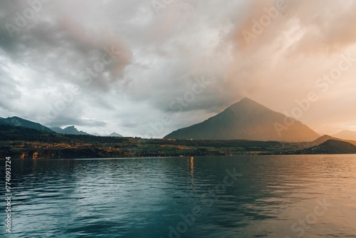 High hill near the Thun lake under the cloudy sky in the evening in Merligen, Switzerland photo