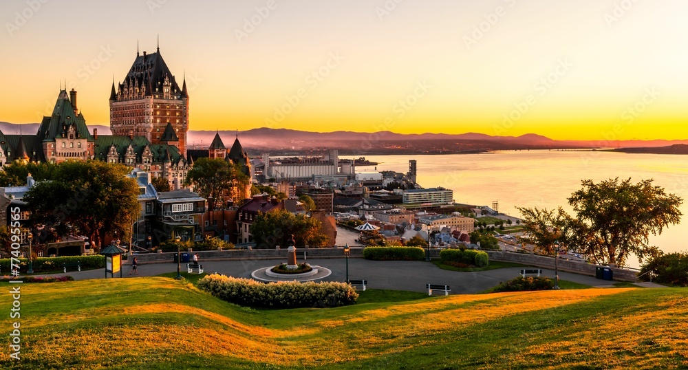 Fototapeta premium Beautiful view of the Chateau Frontenac surrounded by greenery in Quebec, Canada at sunrise