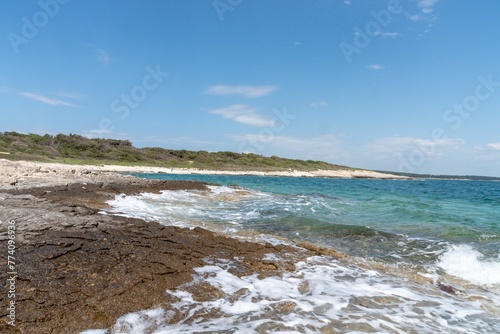 Splashing waves at the rocky coast in Kamenjak photo