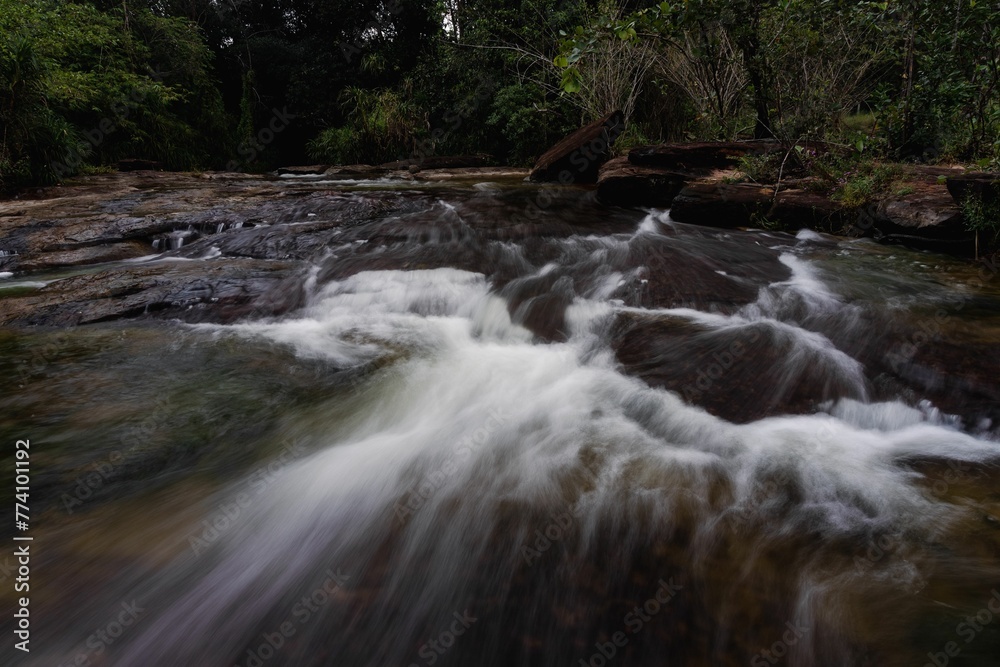 Beautiful long exposure shot of a flowing rocky river in a forest Beautiful long exposure shot of a flowing rocky river in a forest