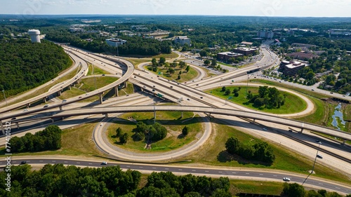 Bird's eye view of cars passing by highway road intersection in shape of clover.