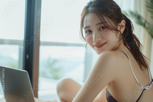 a smiling Japanese woman in white swimwear is captured at her desk, immersed in work on her laptop computer, showcasing dedication and efficiency in her professional tasks. Free Download a smiling Japanese woman in white swimwear is captured at her desk, immersed in work on her laptop computer, showcasing dedication and efficiency in her professional tasks. - GFXLoad