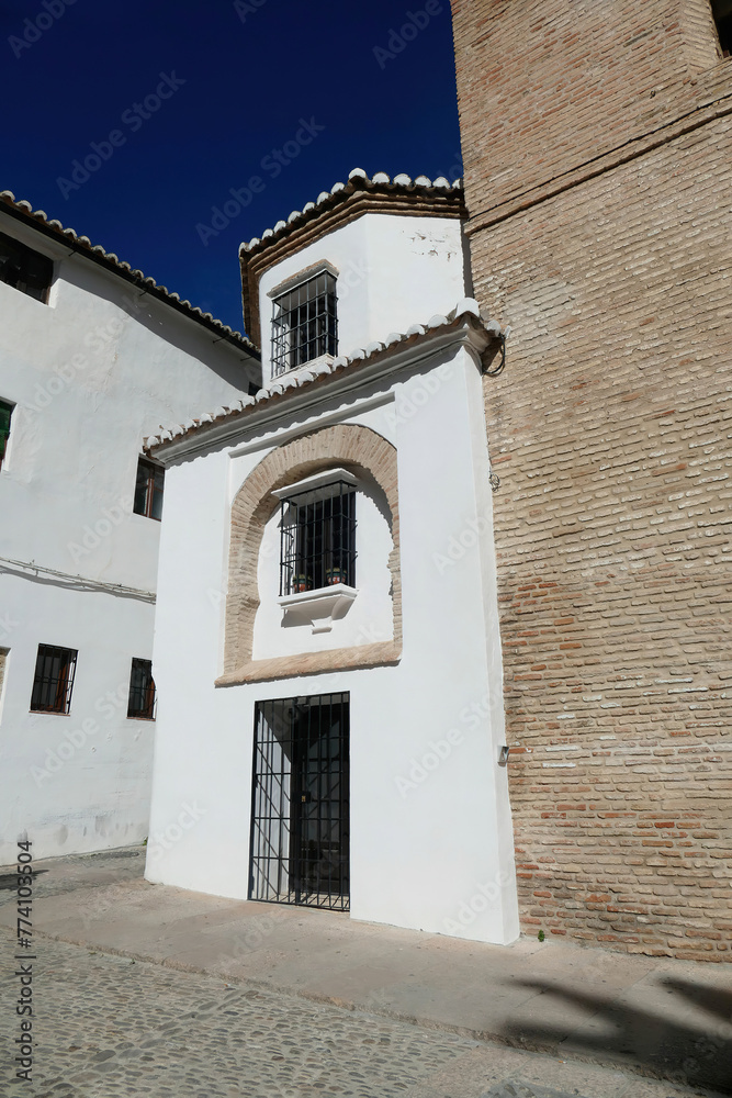 Fototapeta premium Vertical shot of an old white building in small street on a sunny day
