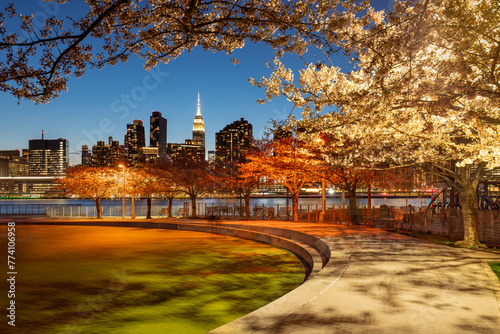 Evening spring in Long Island City Hunter's Point South Park. East River, cherry trees and Manhattan skyscrapers from Queens, New York City photo