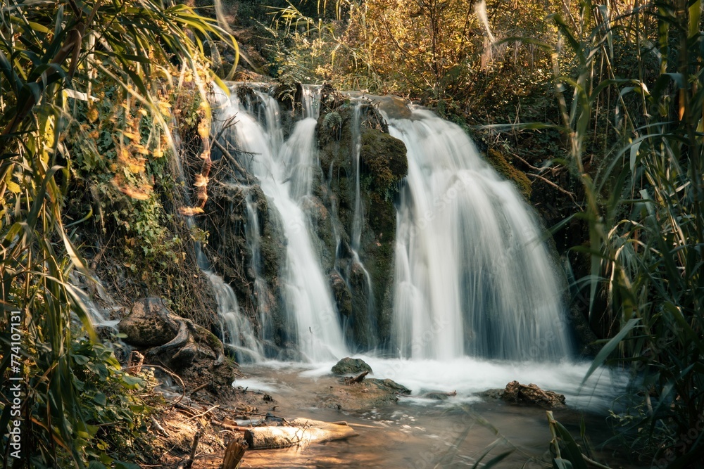 Fototapeta premium Natural view of a beautiful waterfall in a rocky forest