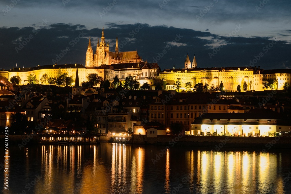Beautiful scenery of illuminated Prague Castle at night reflected on the Vltava river