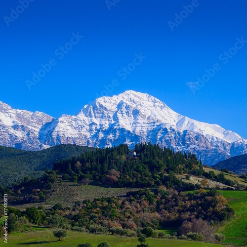 Erymanthos mountain range covered in snow during sunny winter day photo