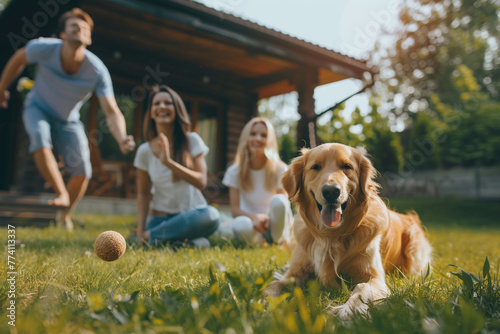 Beautiful family of four playing catch toy ball with golden retriever