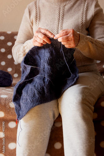 Senior woman knitting at home - stock photo