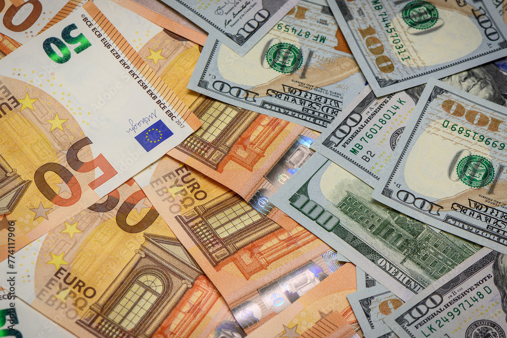 Closeup view of one hundred dollars banknote with euro money banknotes around as financial background.2