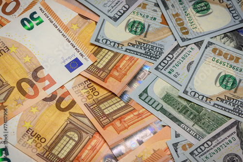 Closeup view of one hundred dollars banknote with euro money banknotes around as financial background.2