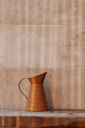 Beautiful Bronze Jug on a Beige Wall Background