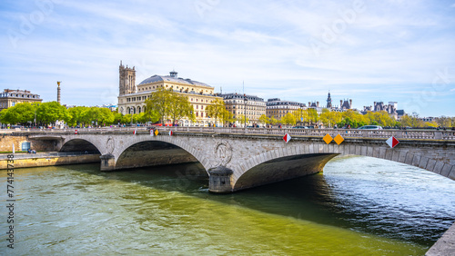Arched Pont au Change spans the Seine River against a backdrop of Parisian architecture on a clear day. Paris, France #774143738