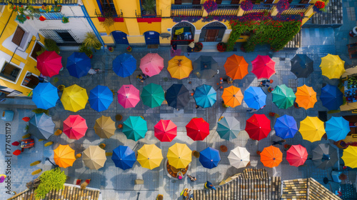 Street in Spain is covered with colorful umbrellas hanging from the sky. these vibrant umbrella art installations that create a stunning visual effect in the urban landscape.