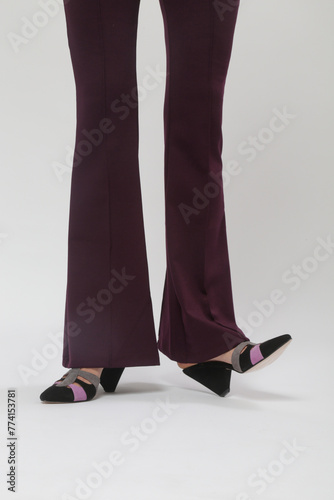 Serie of studio photos of young female model wearing basic flared purple trousers and triangle heel suede sandal