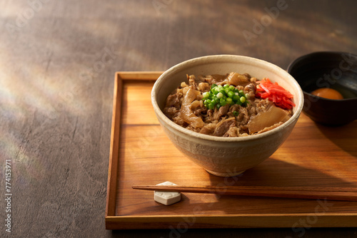 木のお盆にのった白い器の牛丼