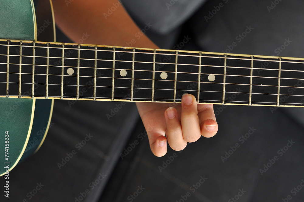 adolescente aprendendo a tocar violão acústico 