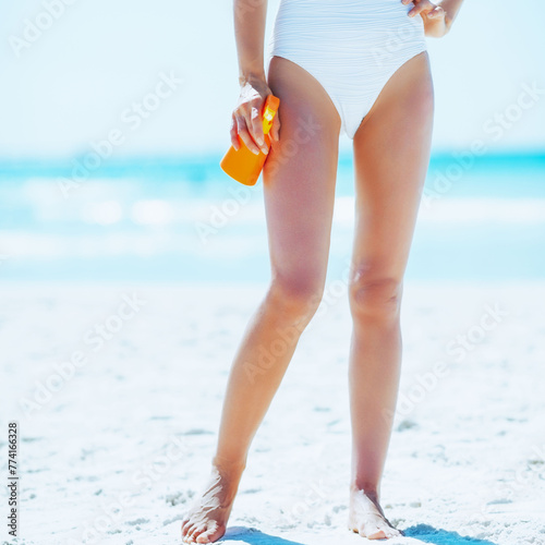 Closeup on young woman with sun block creme on beach