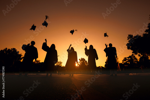 silhouette cheerful graduates in black gowns Graduation hat Thrown in sunset sky