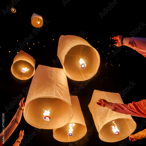 Family hands release hot air paper lanterns to sky at night in Loy krathong and Yi Peng Festival  © nutt