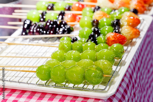 traditional Chinese snack Tanghulu or mix Fruits on skewers coated in a crispy shell of sugar © nutt