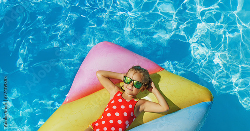 Cute happy girl in swimming resort pool - colorful vacation concept.