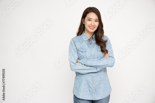 Young beautiful Asian woman in jeans shirt standing and smiling isolated on white background, Looking at camera