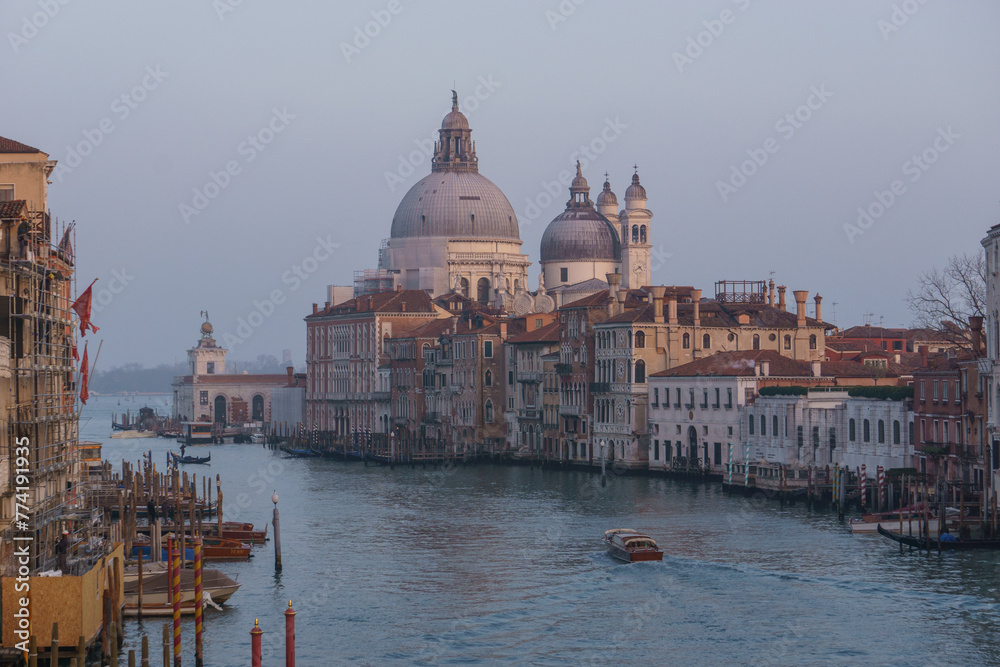 View of Grand Canal and Basilica Santa Maria della Salute seen from the Rialto Bridge on a hazy winter evening, Venice, Veneto, Italy