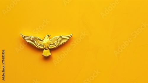 A golden eagle emblem with spread wings centered on a vivid yellow background photo