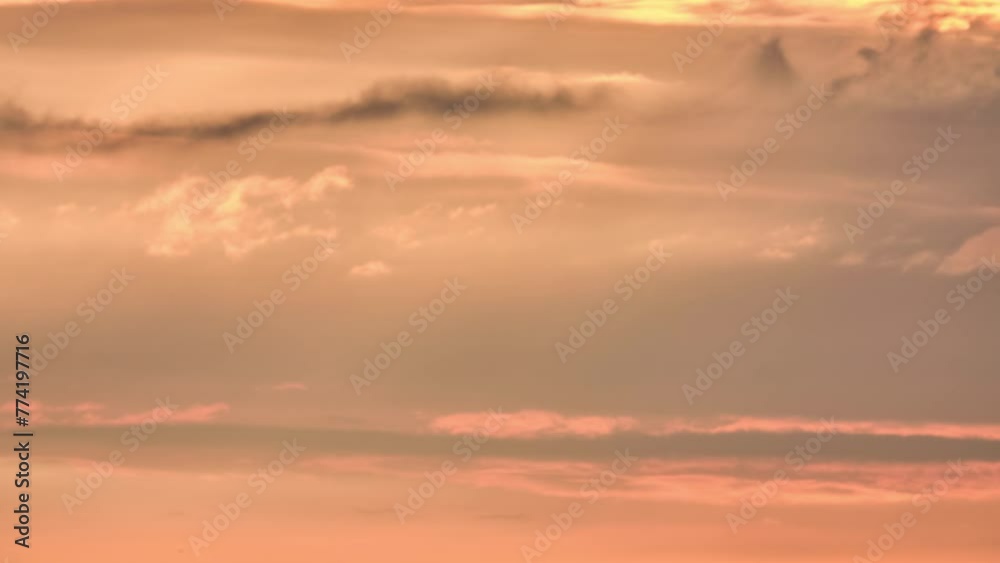 Cloudy evening sky is highlighted by setting sun. Clouds quickly move across sky. Cloudy evening sky is highlighted by setting sun. Clouds quickly move across sky.