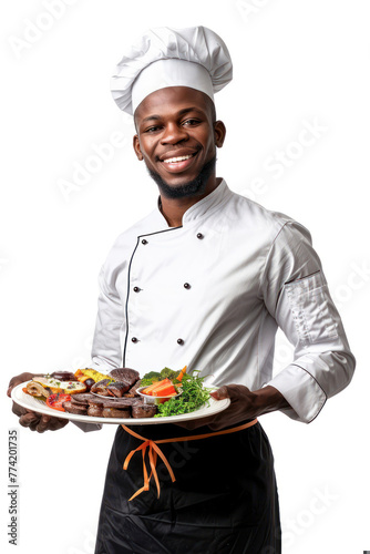 A young chef presents a meticulously arranged plate of meats and sides against a white background for contrast