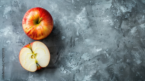 Sliced apple and whole apples on a textured gray background