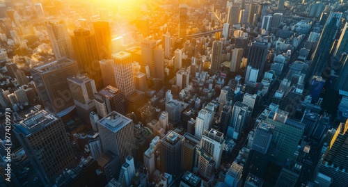 Aerial view of a densely packed urban skyline, with skyscrapers reaching towards the sky, contrasted against the setting sun.