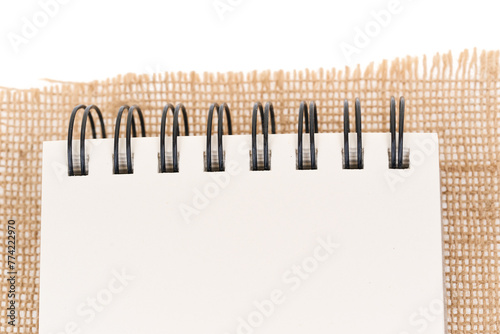 Close-up of notepad on jute, burlap. Notepad on white background - top view.